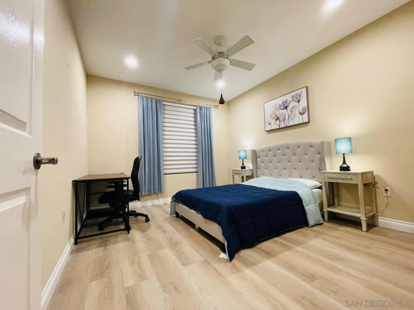 4155 Executive Drive, Unit E210 San Diego, CA 92037 - Photo 10 of 12 a bedroom with a bed and a desk