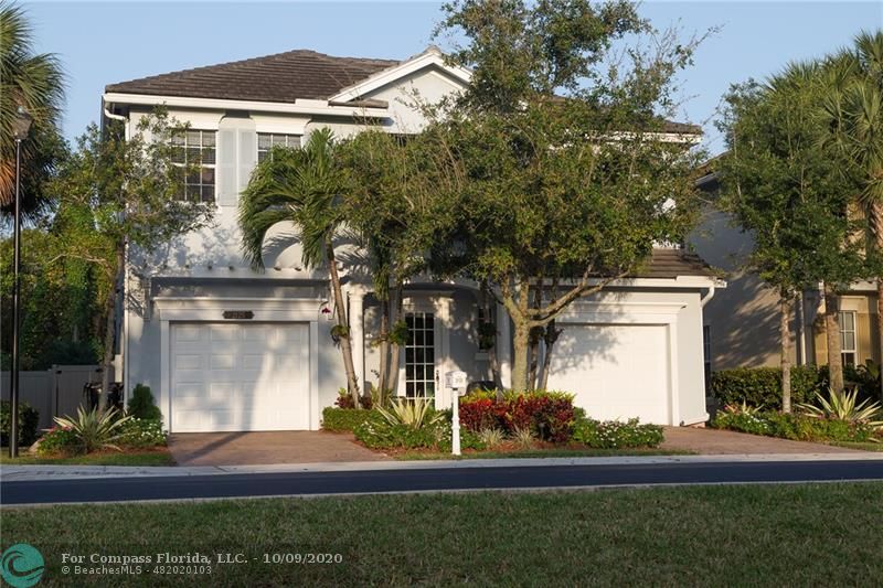 Charming powder blue home has lush landscaping for premium curb appeal, and his and her garages.