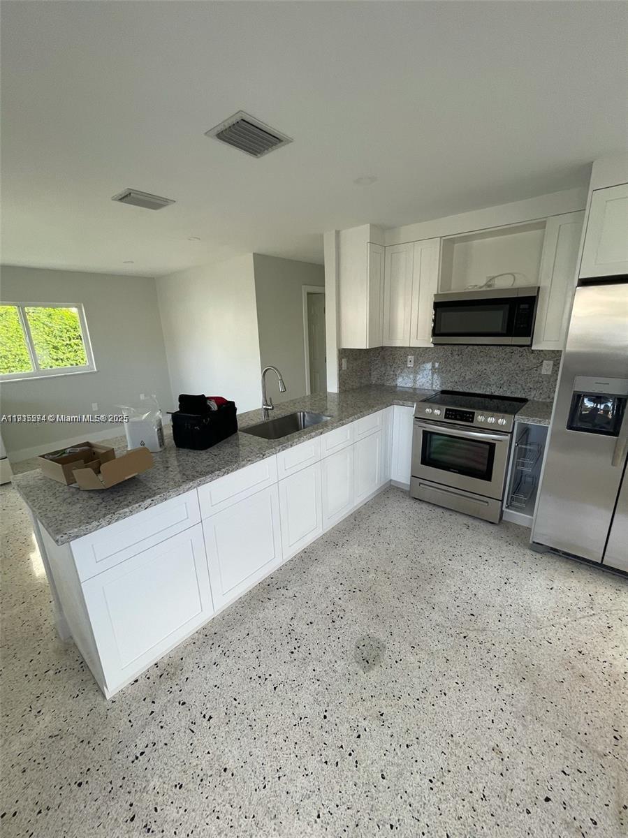 3518 Southwest 24th Terrace, Unit 3518 Miami, FL 33145 - Photo 2 of 11 a kitchen with stainless steel appliances a sink a stove a microwave a refrigerator a counter top space and cabinets
