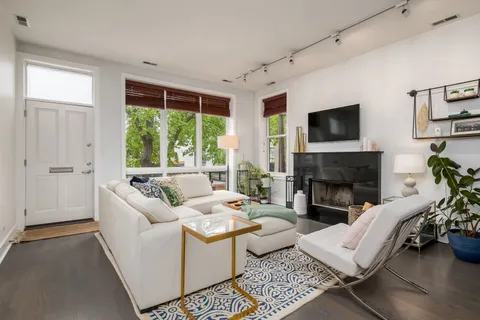 a living room with furniture large window and a fireplace