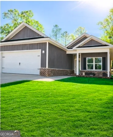 a front view of a house with a yard and potted plants