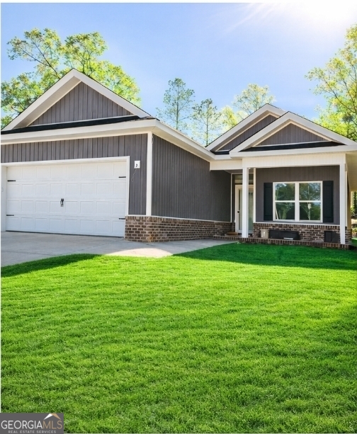 a front view of a house with a yard and potted plants
