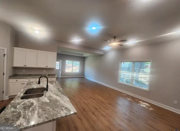 a kitchen with kitchen island granite countertop white cabinets and appliances