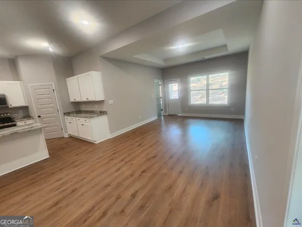 a view of a kitchen with wooden floor and electronic appliances
