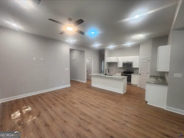 a view of kitchen with refrigerator microwave and stove