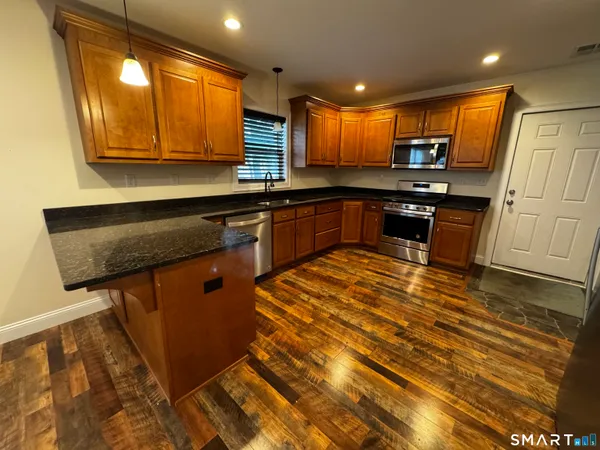 a kitchen with stainless steel appliances granite countertop a sink stove and cabinets
