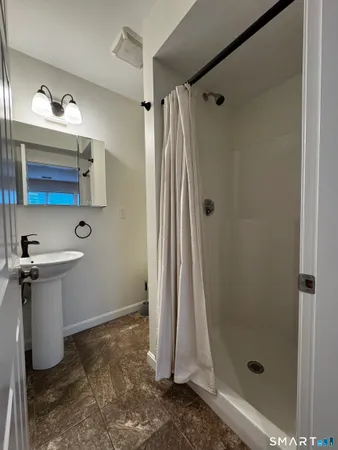 a bathroom with a shower a sink and a mirror