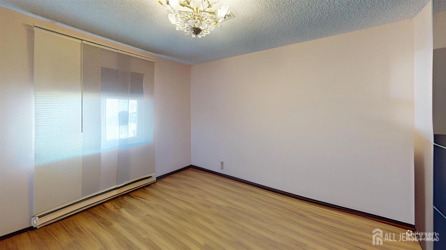 452A Closter Road, Unit B Monroe Township, NJ 08831 - Photo 14 of 46 an empty room with wooden floor and windows
