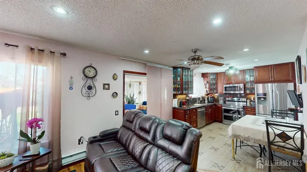 a living room with furniture kitchen view and a window
