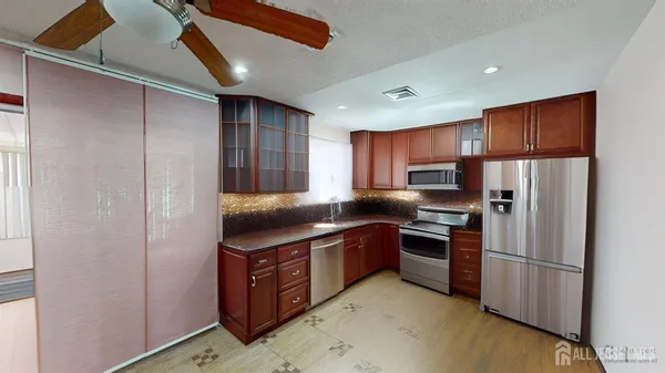 a kitchen with stainless steel appliances granite countertop a refrigerator a stove and a sink