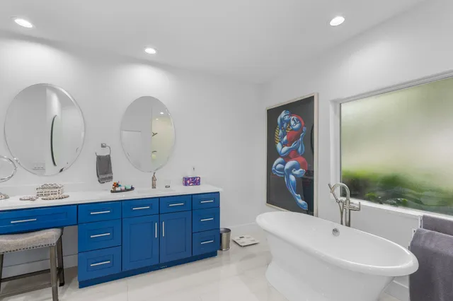 a spacious bathroom with double vanity a toilet a shower and a mirror