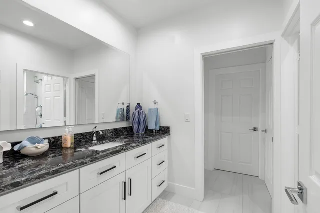 a bathroom with a granite countertop sink and a mirror