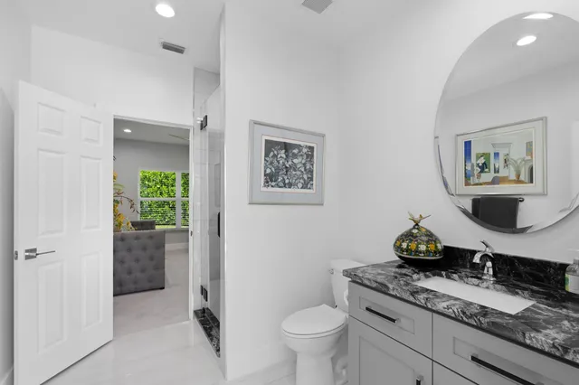 a room with a granite countertop toilet and a sink