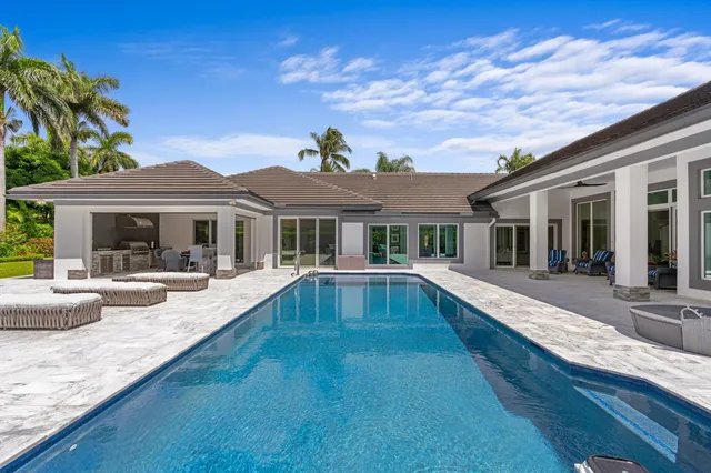 a view of a house with swimming pool and sitting area