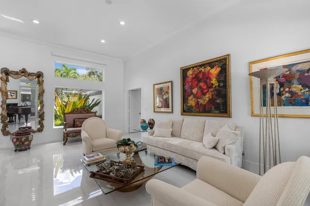 a living room with furniture a couch and paintings on the wall