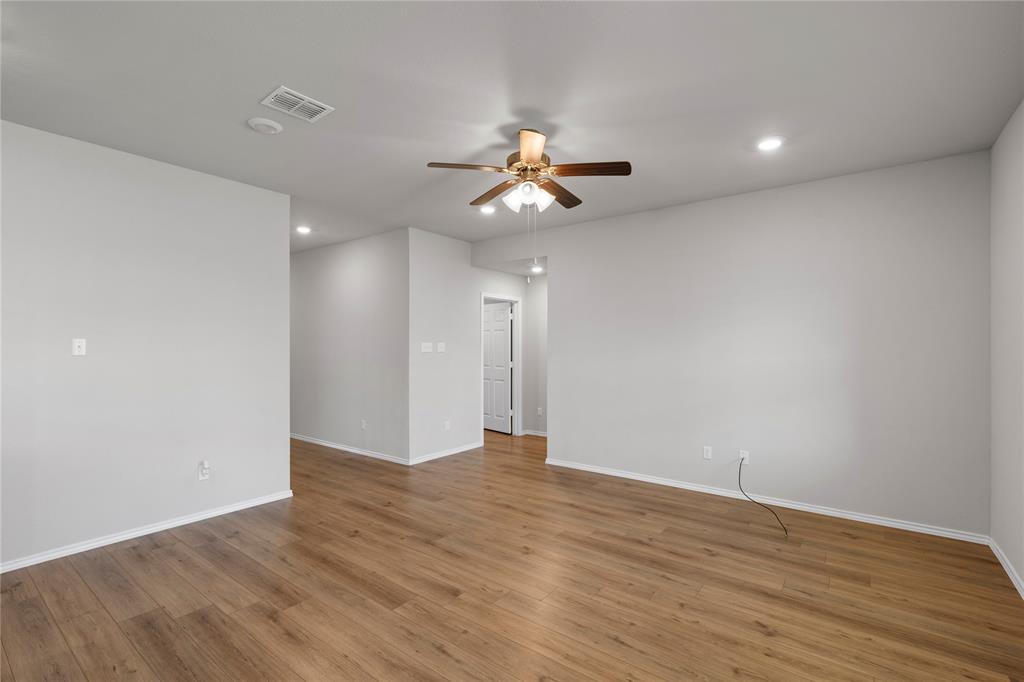 3012 Sherco Road Lorena, TX 76655 - Photo 2 of 14 a view of an empty room with chandelier fan and wooden floor
