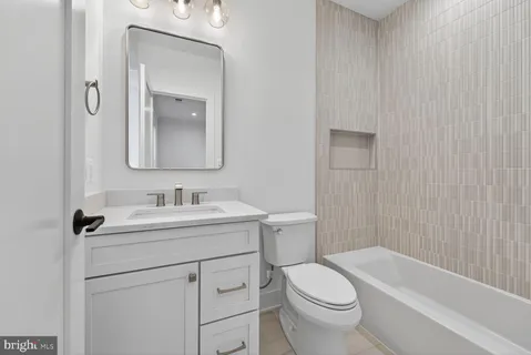 a bathroom with a sink toilet vanity granite tub and shower