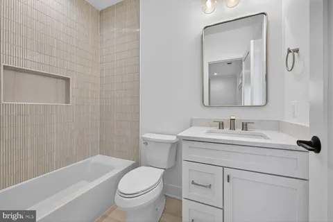 a bathroom with a sink toilet vanity and tub