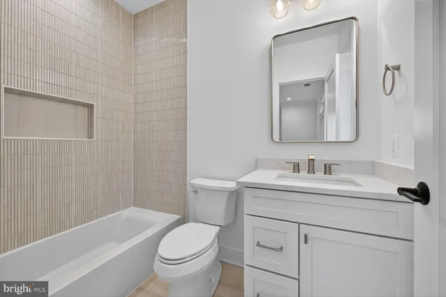 a bathroom with a sink toilet vanity and tub