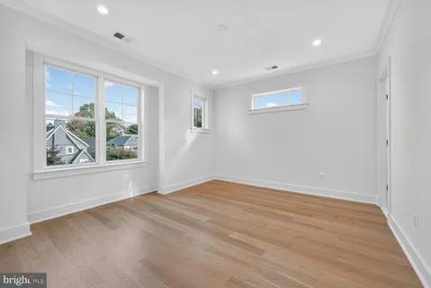 a view of empty room with window and wooden floor