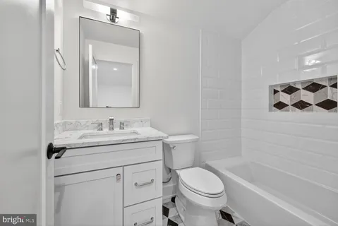 a bathroom with a granite countertop sink toilet mirror and shower