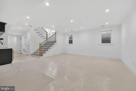 an empty room with wooden floor and white walls