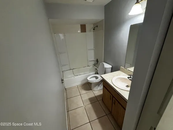 an empty room with windows and refrigerator