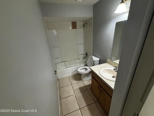 an empty room with windows and refrigerator