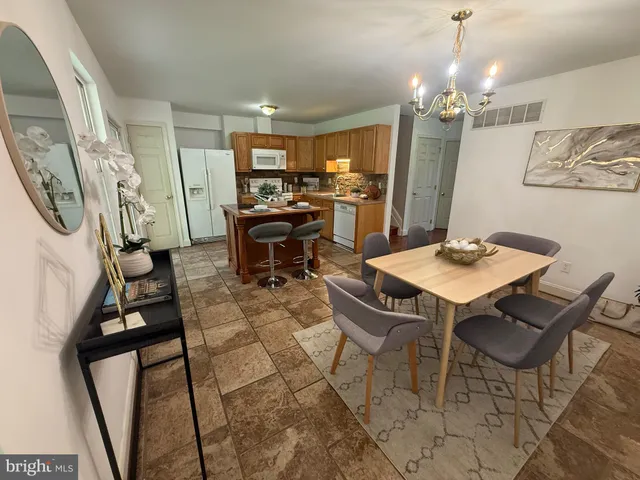 a view of a dining room with furniture and a chandelier