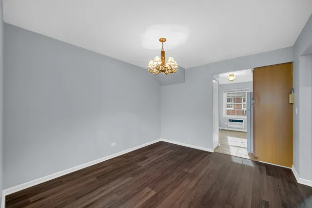 a room with wooden floor and chandelier