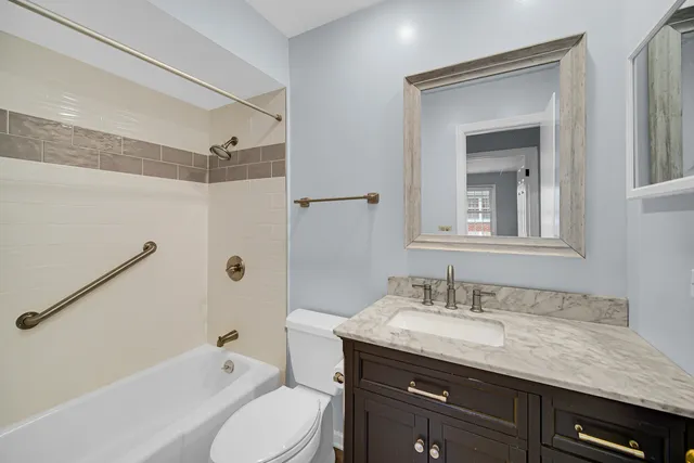 a bathroom with a granite countertop sink a toilet and shower