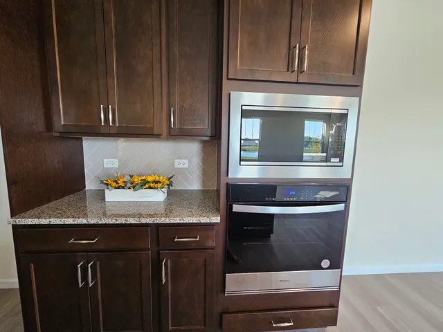 a kitchen with granite countertop cabinets and black appliances
