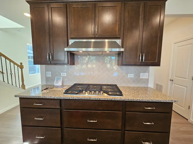 a kitchen with granite countertop stainless steel appliances stove and cabinets