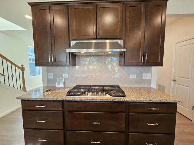 a kitchen with granite countertop stainless steel appliances stove and cabinets