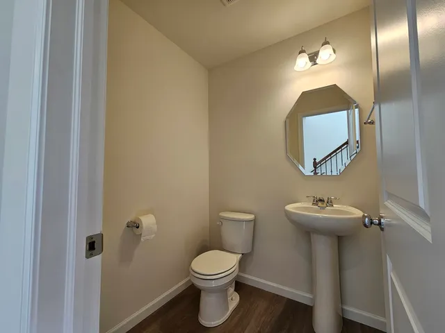 a bathroom with a toilet sink and mirror
