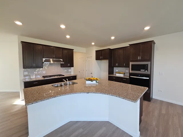 a large kitchen with stainless steel appliances and a refrigerator