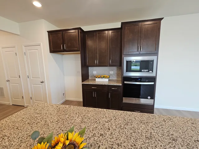 a kitchen with granite countertop a refrigerator and a stove top oven