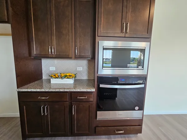 a kitchen with granite countertop wood cabinets and stove