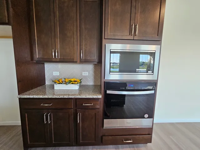 a kitchen with granite countertop wood cabinets and stove