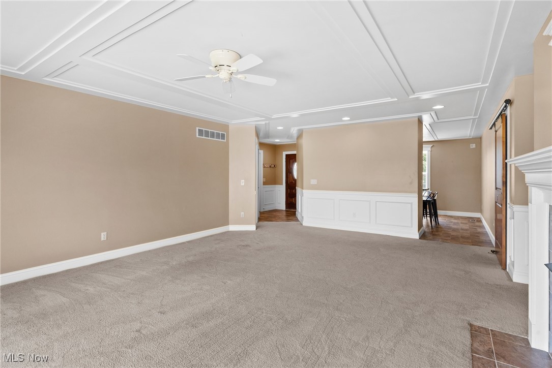 5215 River Road Madison, OH 44057 - Photo 7 of 36 Unfurnished living room featuring attic access, carpet flooring, ceiling fan, recessed lighting, and crown molding
