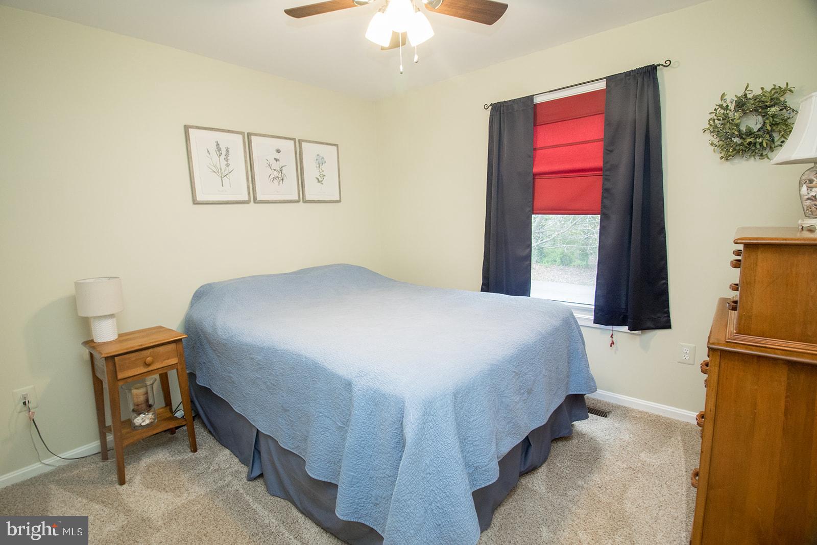 11620 Big Sandy Run Road Lusby, MD 20657 - Photo 12 of 64 a bedroom with a bed and a chandelier