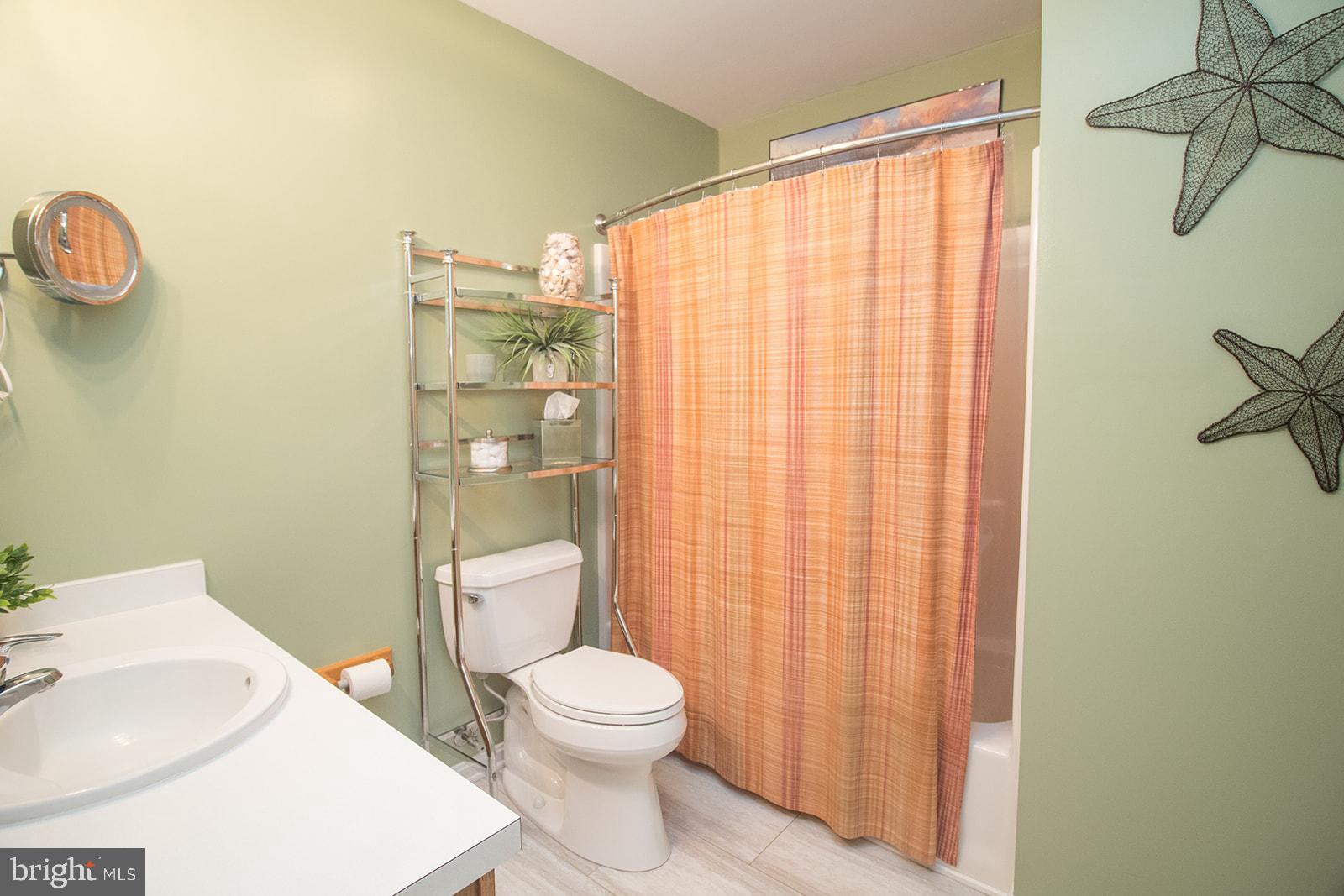 11620 Big Sandy Run Road Lusby, MD 20657 - Photo 20 of 64 a bathroom with a toilet a sink and shower curtain