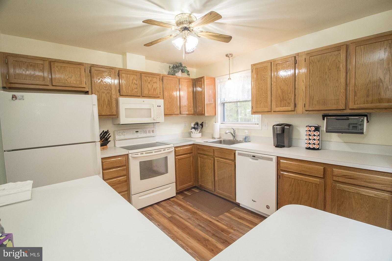 11620 Big Sandy Run Road Lusby, MD 20657 - Photo 32 of 64 a kitchen with a white cabinets and white appliances