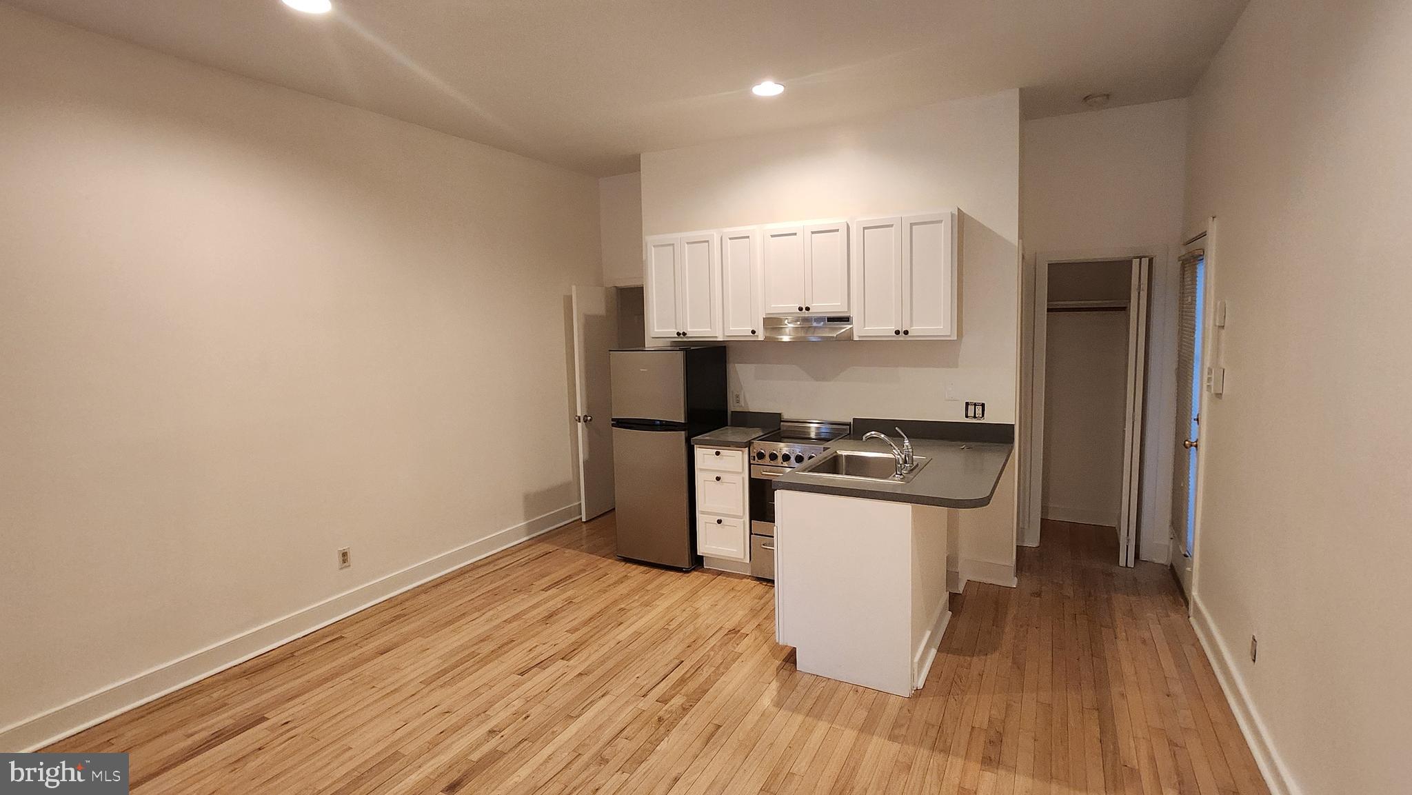 459 M Street Northwest, Unit A Washington, DC 20001 - Photo 3 of 10 a kitchen with wooden floor and stainless steel appliances