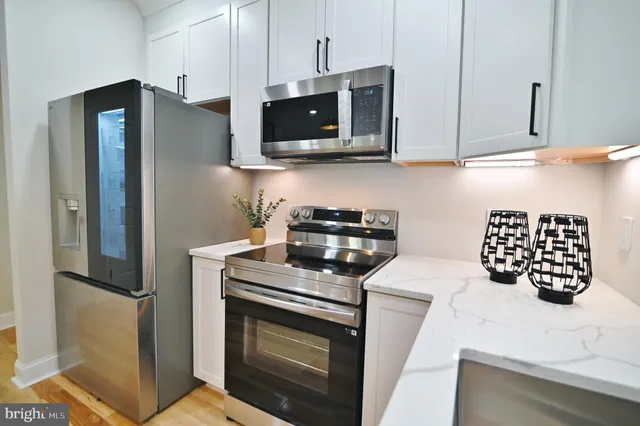 a living room with a fireplace and potted plants