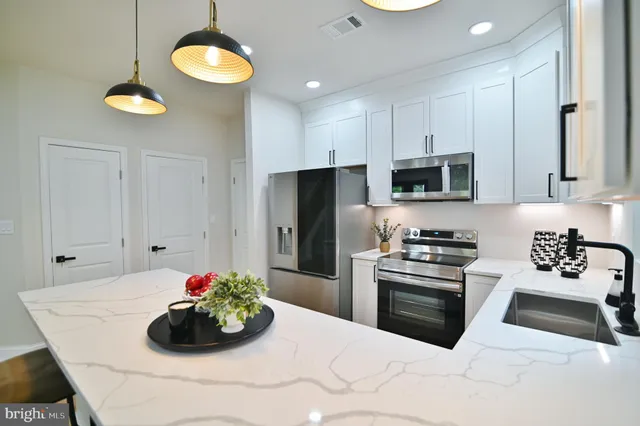 a living room with a fireplace and potted plants