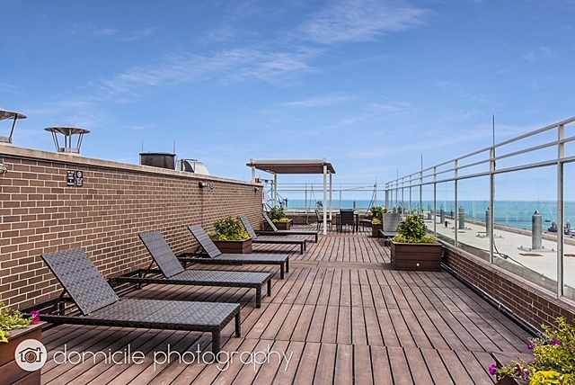 260 East Chestnut Street, Unit 3201 Chicago, IL 60611 - Photo 12 of 15 a view of a balcony with chairs and wooden floor