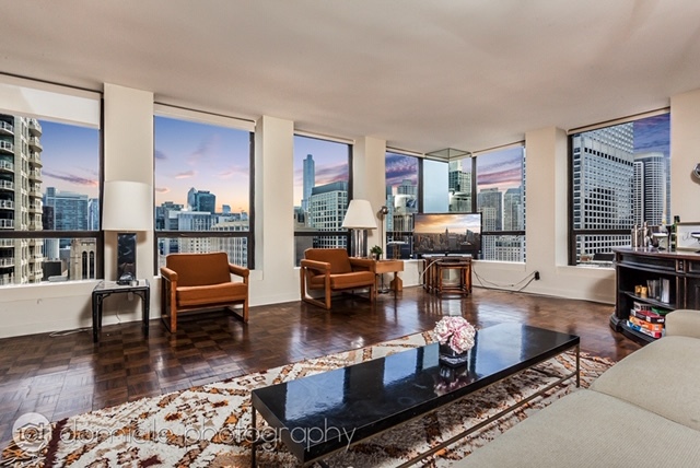 260 East Chestnut Street, Unit 3201 Chicago, IL 60611 - Photo 3 of 15 a living room with fireplace furniture and a wooden floor