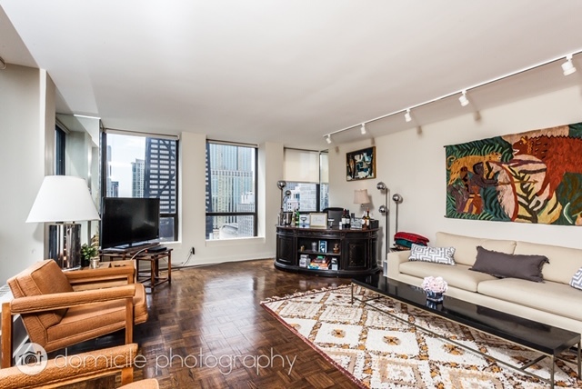 260 East Chestnut Street, Unit 3201 Chicago, IL 60611 - Photo 5 of 15 a living room with furniture and a flat screen tv