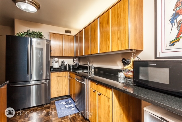 260 East Chestnut Street, Unit 3201 Chicago, IL 60611 - Photo 7 of 15 a kitchen with granite countertop stainless steel appliances a refrigerator microwave and sink